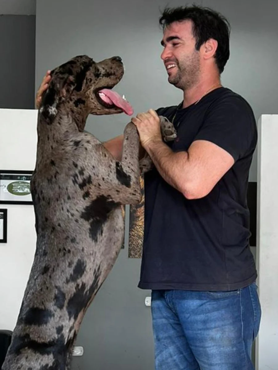 Capitão Cacciari, à paisana, brincando com seu cão dogue alemão